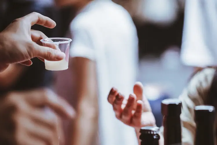 試飲用のカップを持つ手元